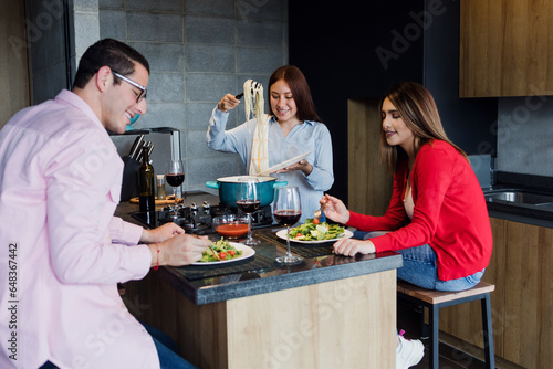 latin friends cooking and eating together in kitchen at home in Mexico Latin America, hispanic people preparing food