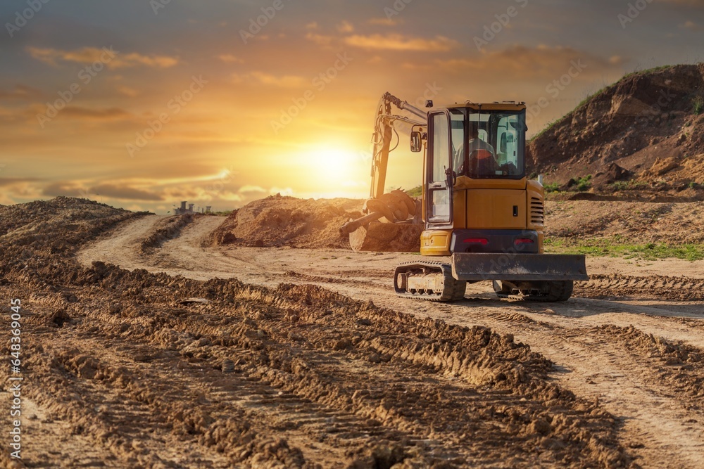 Crawler excavator working on a construction site at sunset Crawler excavator working on a construction site at sunset