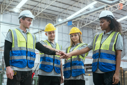 Group of technicians and employees in a paper mill holding hands and talking Collaborate with the team to work in the warehouse.