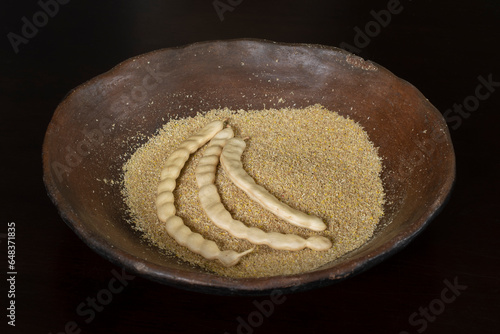 Mesquite flour and pods in rustic ceramic plate