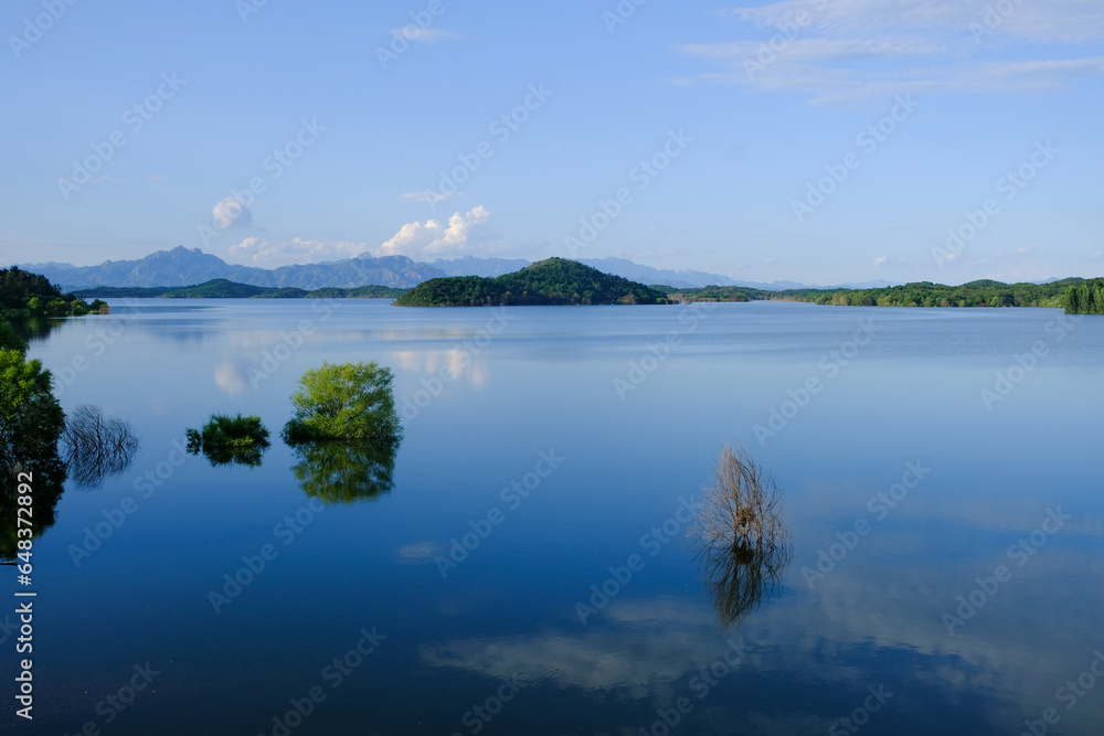 white clouds,blue sky,blue lake,green plants and green mountains. 