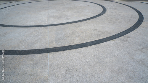 The cement floor has black stripes alternating in circles as the background image.