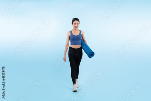 Young attractive asian woman portrait in sportswear with exercising mat. Healthy exercise and workout routine lifestyle concept. Studio shot isolated background. Vigorous