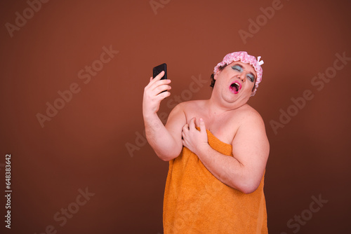 Beauty and healthy lifestyle. Funny fat man posing after a shower. Brown background.