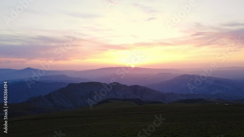 Picturesque dawn sunset sunrise mountain summit landscape bright sun sky horizon aerial static view. Drone shot cinematic darkness evening morning cliff rock scenery panorama colorful sunshine beams
