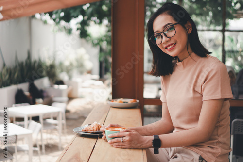 Young asian woman drinking coffee latte at a cafe
