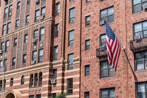 american flag on brick brownstone building. architectural exterior and facade. new york city architecture. brownstone building architecture of new york. modern city