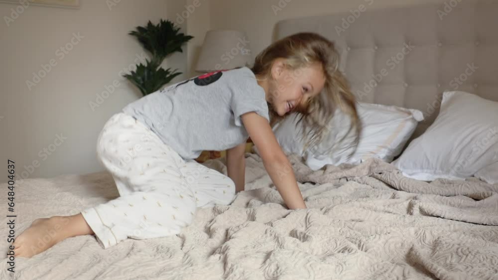 Happy active preschooler girl have fun jumping high on comfortable mattress on bed at home, excited little child enjoy playing alone leap and hop in white bedroom funny activity Happy active preschooler girl have fun jumping high on comfortable mattress on bed at home, excited little child enjoy playing alone leap and hop in white bedroom funny activity