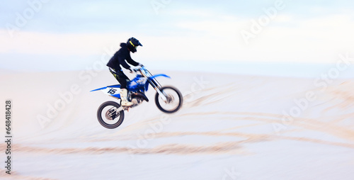Sand, jump or athlete driving motorcycle for fitness, adventure or action with performance or adrenaline. Desert, risk or sports person on motorbike on dunes for training, exercise or race challenge