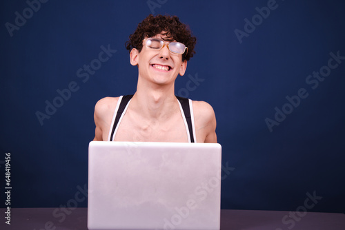 Funny curly guy watches an adult video at home. Blue background. photo