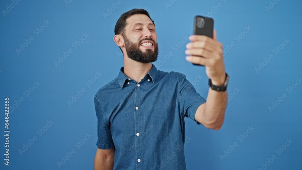 Young hispanic man smiling confident having video call over isolated blue background Young hispanic man smiling confident having video call over isolated blue background