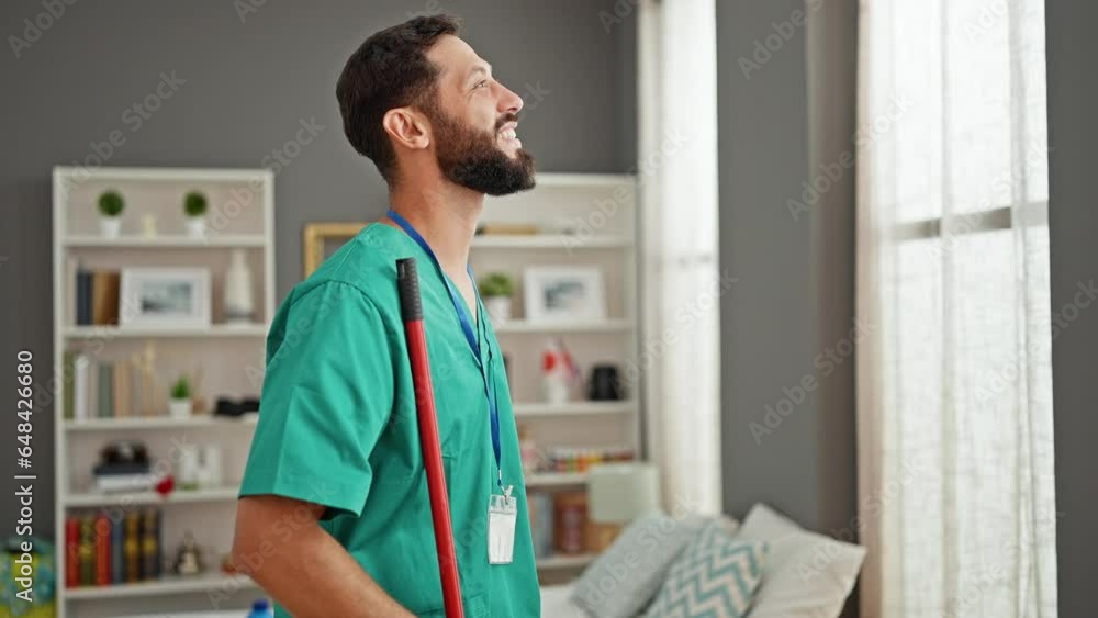 Young hispanic man professional cleaner smiling confident looking watch at bedroom Young hispanic man professional cleaner smiling confident looking watch at bedroom