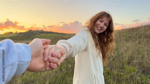 Happy couple walk on nature, summer field, girl take her boyfriend with hand, follow me. Relationship concept. 