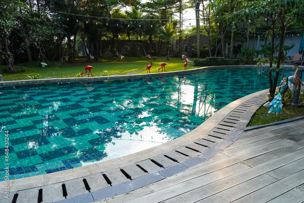 Blue water swimming pool and wooden deck, summer on a sunny day suitable for sports or relaxing on holiday or sports to burn calories