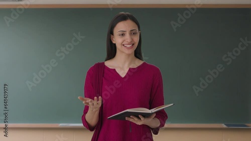 Happy Indian female teacher teaching in class