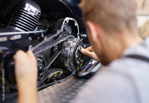 Male service man hold silver key in hand closeup. Motorcycle repair concept