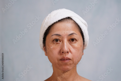 シミ、シワのある老け顔の中年女性 カメラ目線
