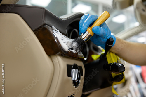 Car detailing, procedure, closeup master washing dashboard with soft brush