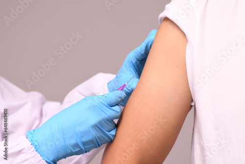 Close up of patient's shoulder vaccination, influenza vaccination in arm, coronavirus, covid-19 vaccine preparation for human clinical trial vaccination.