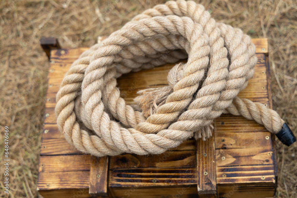 A twisted thick rope lies on a wooden box
