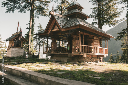 Shangchul mahadev temple in the meadow of Shahgarh, surrounded by Deodar Tree and Himalayas mountains in Sainj Valley, Great Himalayan National Park, Himachal Pradesh.