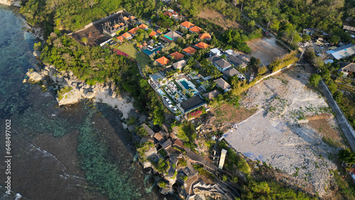 Aerial view of uluwatu cliff face, crystal clear water and blue sky