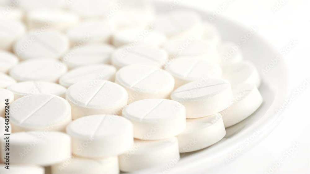 White medical pills in plate, rotating. Pills and drugs. Pharmaceutical Industry White medical pills in plate, rotating. Pills and drugs. Pharmaceutical Industry