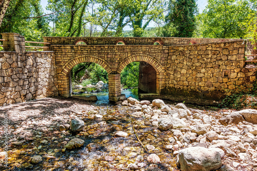 Old, stone, arched bridge across the river near Agia Theodora of Vasta church in Peloponnese, Greece. photo