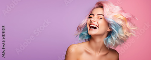 Young beautiful smiling happy woman with rainbow colored wavy hair isolated on flat purple background with copy space, banner template of Creative hair coloring.