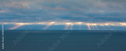 Beams of sunlight sneaking through the clouds photo