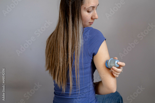 Girl applying flash glucose monitoring patch on her arm photo