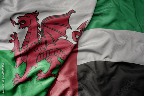 big waving national colorful flag of wales and national flag of united arab emirates .