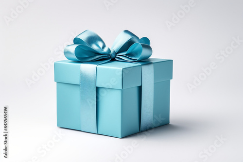 Elegant blue gift box with a shimmering ribbon on a pristine white background © Ash