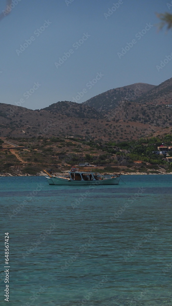 A group of unrecognizable divers explore a sunken shipwreck in the blue, mediterranean sea at Naxos island, Greece	