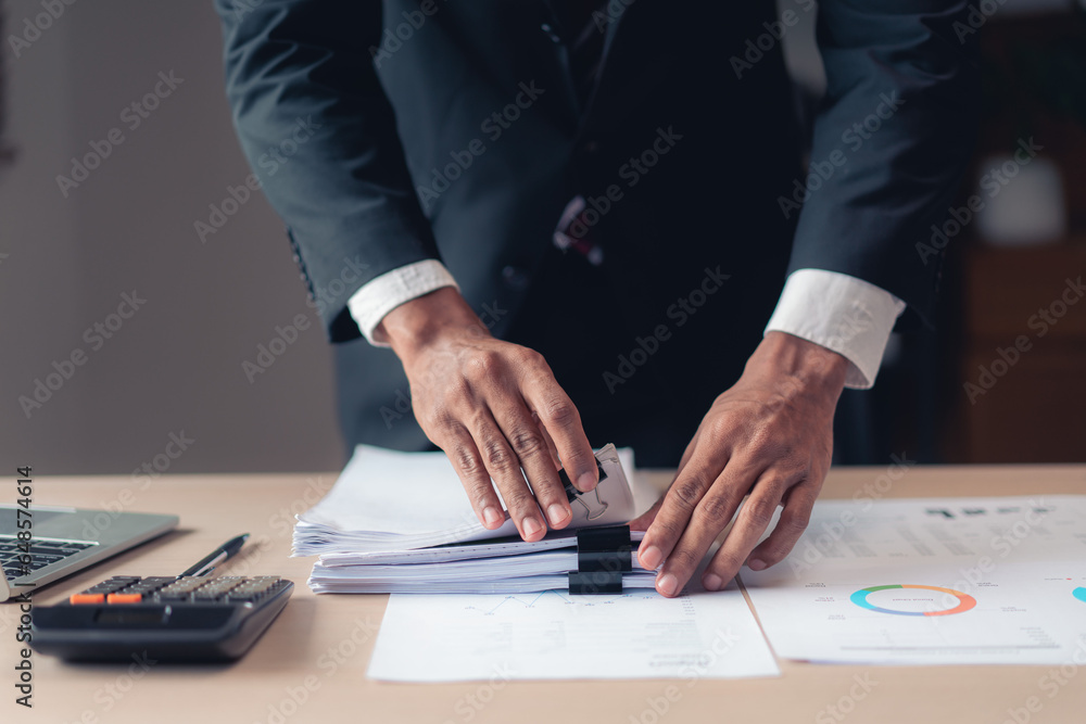 Businessman stacking document after checking financial and accounting report of business project Businessman stacking document after checking financial and accounting report of business project