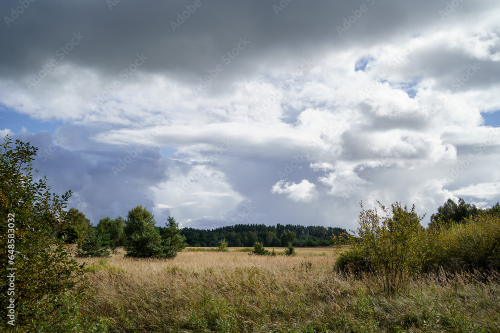 white rain clouds over countryside in summer