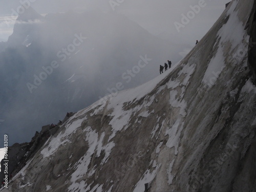 A group of skiers and start the descent of Valle Blanche, the most famous offpist run in the Alps, Valle Blanche descent links Italy and France through the Mont Blanc Massif. Chamonix, France, Europe. photo