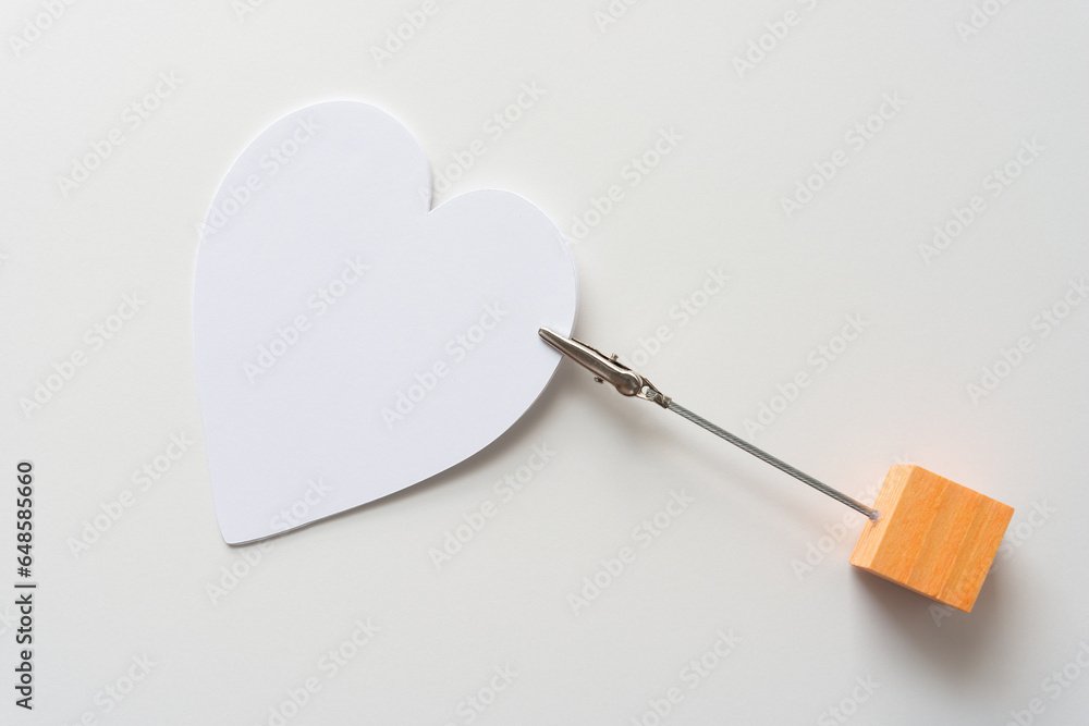 orange cube and metal clip holding a white paper heart orange cube and metal clip holding a white paper heart