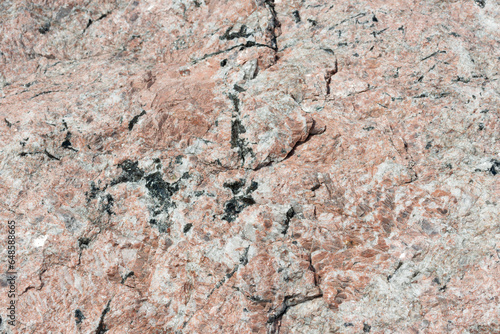 surface of pink granite in the sun (with other mineral deposits)