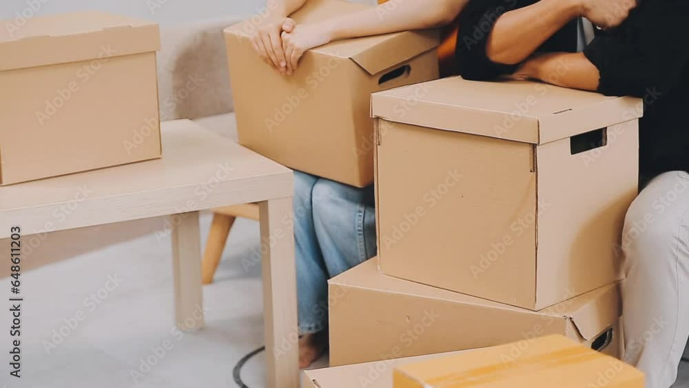 .Two people couple interracial family ameste in living room in new apartment open cardboard boxes receive parcels with orders from internet store with new interior items rejoice at courier delivery .Two people couple interracial family ameste in living room in new apartment open cardboard boxes receive parcels with orders from internet store with new interior items rejoice at courier delivery