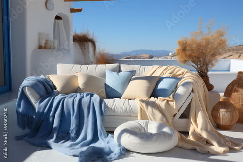 Light blue and beige terrace with sofa, blankets and pillows, at the sea, blue sky in the background. Copy space photo