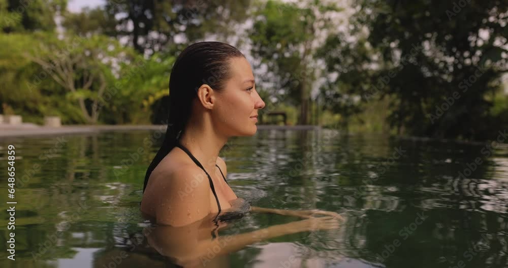 Amazing bathing spa woman pops up from a luxurious infinity pool, wearing a fashionable bikini and flaunting her perfect tanned buttocks. Cinematic slow-motion video in 4k Amazing bathing spa woman pops up from a luxurious infinity pool, wearing a fashionable bikini and flaunting her perfect tanned buttocks. Cinematic slow-motion video in 4k