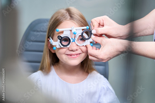 Qualified ophthalmologist performing subjective refraction test on child