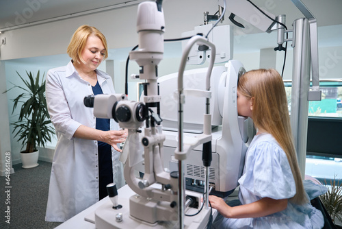 Optometrist determining pediatric patient refractive power with autorefractor photo