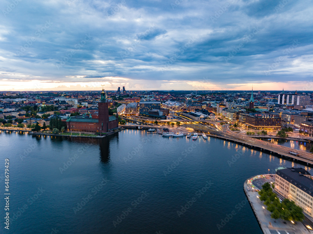 Aerial view of evening city. Transport infrastructure and popular landmarks at sunset. Famous City Hall on waterfront. Stockholm, Sweden