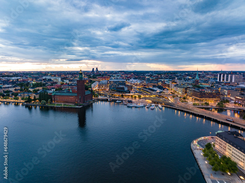 Aerial view of evening city. Transport infrastructure and popular landmarks at sunset. Famous City Hall on waterfront. Stockholm, Sweden