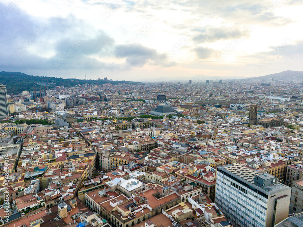 Aerial panoramic view of historic quarter of metropolis. Buildings and narrow aisles in large city at dusk. Barcelona, Spain