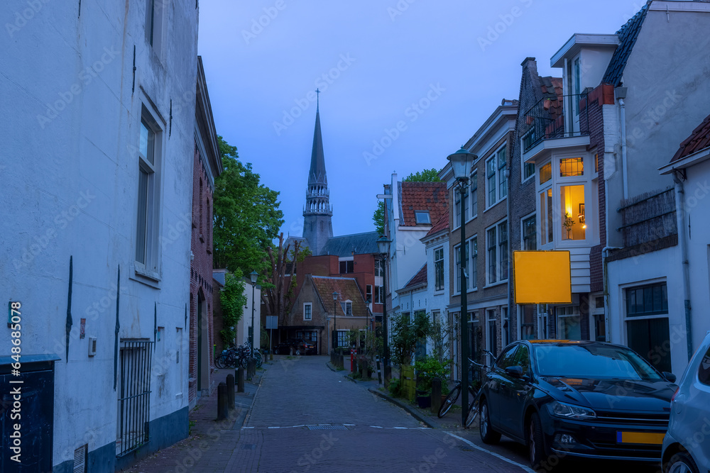 Beautiful street leading to historic Saint-John Church in Gouda, Netherlands.