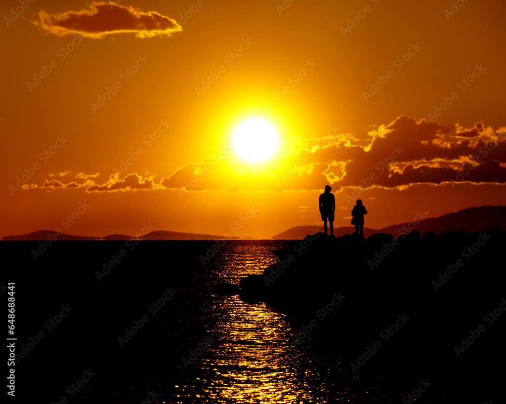 Intensive orange sunset with contrast black silhouette on the shiny background