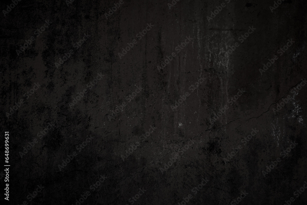 Front view of a dirty, worn and weathered dark gray concrete wall with paint partly faded. Abstract full frame textured background in black and white with copy space.